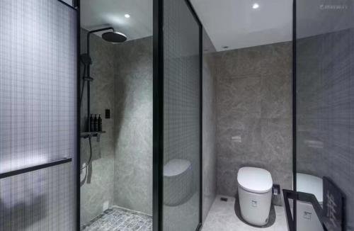 a bathroom with a shower and a toilet in it at Shantou New Town Huanghe Road Yifei Hotel in Xialian