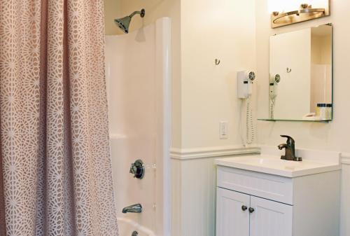 a bathroom with a shower curtain and a sink at Sandwich Inn and Suites in Sandwich