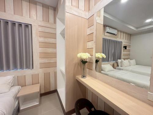 a room with two beds and a desk with a mirror at Sunrise House at Lanta in Ban Nong Chaeng