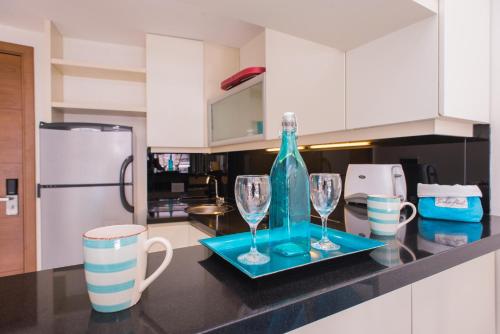 a kitchen with a blue bottle and two glasses on a counter at Soho Luxury Suites in Buenos Aires