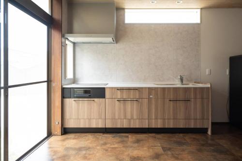大山町にあるDAISEN UMIHOTARU Entire houseの木製のキャビネットとシンクを備えたキッチン