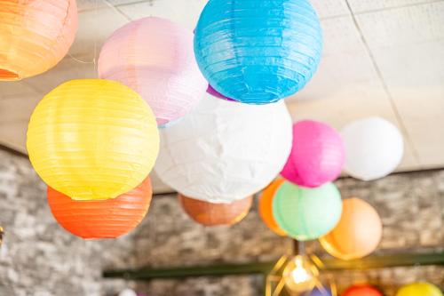 a bunch of colorful paper lanterns hanging from a ceiling at Lax奈良 奈良観光に便利な和モダン古民家 最大12名 グループや家族旅行に最適 in Nara