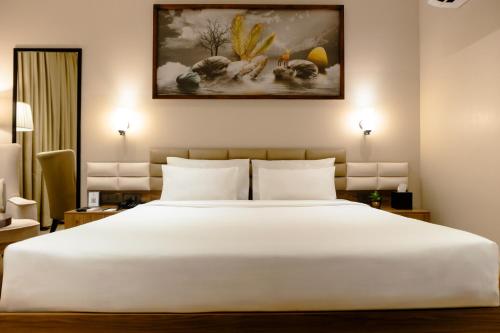 a bedroom with a large white bed in a room at Udman Hotel Gurugram in Gurgaon