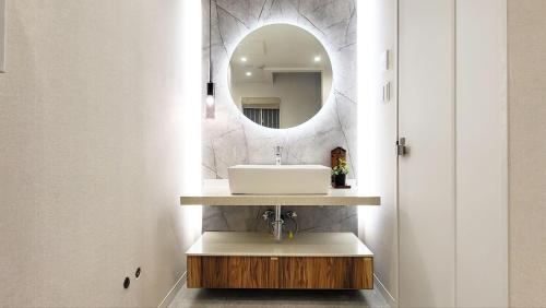 ein Badezimmer mit Waschbecken und Spiegel in der Unterkunft STAY ARI Higashishinjuku in Tokio