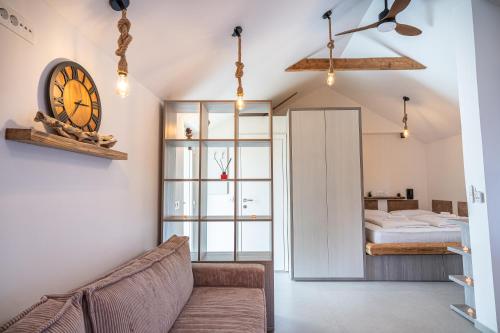 a living room with a couch and a clock on the wall at Hill Stars House in Straža