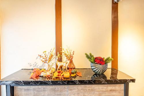 a table with flowers and vases on it at Lax奈良 奈良観光に便利な和モダン古民家 最大12名 グループや家族旅行に最適 in Nara