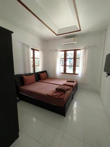 a bedroom with a large bed in a room with windows at Kood Life in Ko Kood