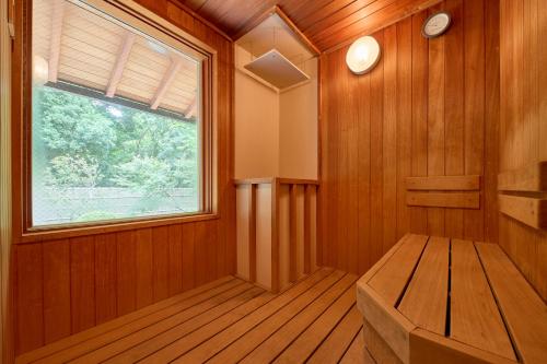 a sauna with a window and a bench in it at Akazawa Geihinkan in Ito