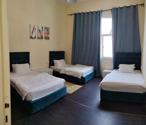 a room with two beds and a window at Lunar Beach Hostel in Abu Dhabi