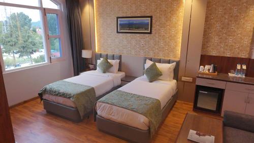 a room with two beds in a hotel room at The Grand Mamta in Srinagar