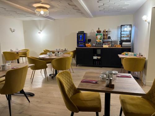a restaurant with tables and chairs in a room at Hôtel Comme chez soi in Jas