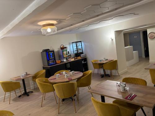 a dining room with wooden tables and chairs at Hôtel Comme chez soi in Jas