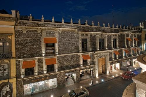a large brick building with a street at night at Downtown in Mexico City