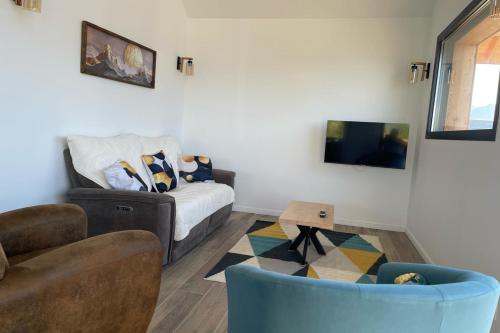 Puy-SanièresにあるSpacious house with stunning views Puy-Sanièresのソファとテレビのあるリビングルーム