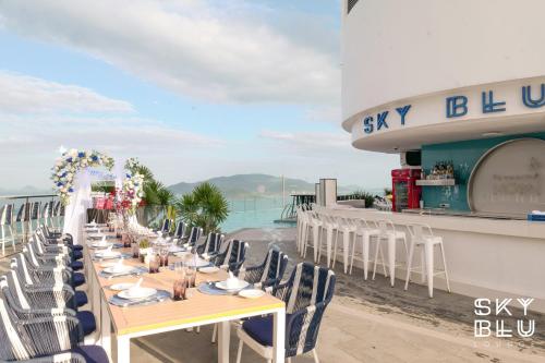 a table on the beach with chairs and a sky blue restaurant at MAISON SEAFRONT RESIDENCE Nha Trang in Nha Trang