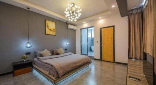 a bedroom with a large bed and a chandelier at Dali Four Seasons Hostel in Dali Ancient Town