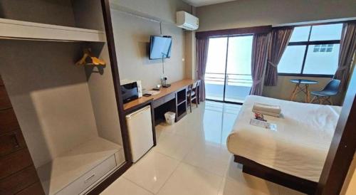 a hotel room with a bed and a television at Wsotel Hotel in Songkhla