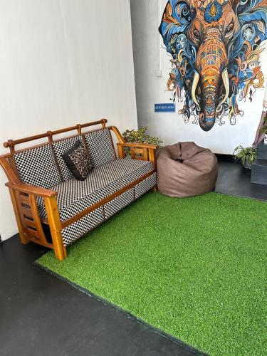 a living room with a couch and a green rug at Night manner hostel in Ella