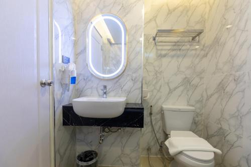 a bathroom with a sink and a toilet and a mirror at Airbus Hotel At Phawana Station in Bangkok