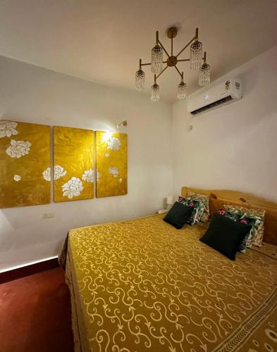 Un dormitorio con una cama y una lámpara de araña. en House of Bamboos, en Anjuna