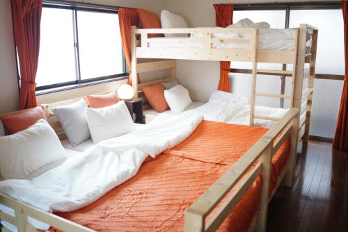 two bunk beds in a room with windows at MarunoStay-最大8名-プロジェクター完備-アクセス良好-岡山城後楽園徒歩圏内 in Okayama