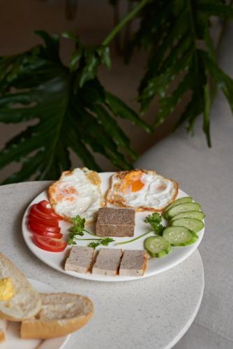 a plate of food with eggs and vegetables on a table at Jacayl Hotel - Cầu Giấy in Hanoi