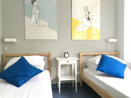 2 łóżka z niebieskimi poduszkami w pokoju w obiekcie Cloud Hostel w Warszawie