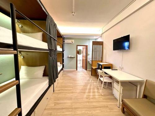a dorm room with bunk beds and a desk at Need a Nap Hostel Phrae in Phrae