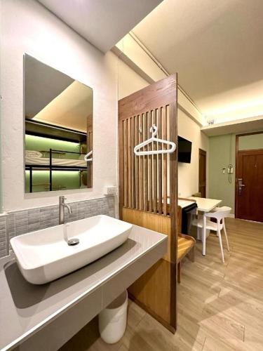 a bathroom with a sink and a mirror at Need a Nap Hostel Phrae in Phrae
