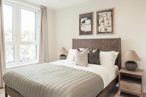 a white bedroom with a large bed with pillows at Urban Rest Bermondsey in London