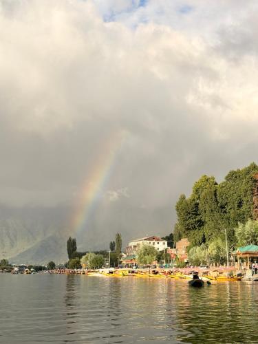 a rainbow over a lake with a group of boats at Majestic empire group of houseboat in Srinagar