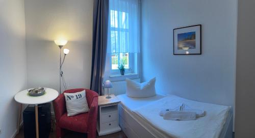 a bedroom with a bed and a table and a chair at Pension Villa Frohsinn Sellin auf Rügen in Ostseebad Sellin