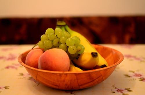 a wooden bowl filled with fruit on a table at Guest House Konjic in Konjic