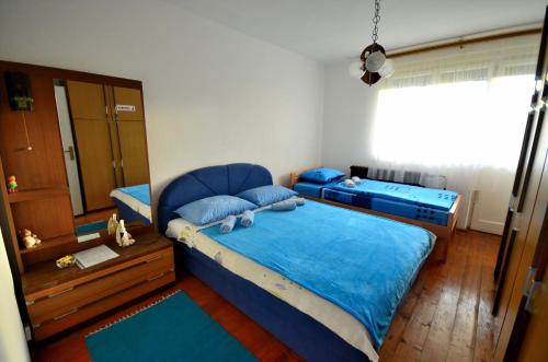 a bedroom with a blue bed and a window at Guest House Konjic in Konjic
