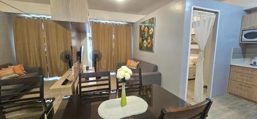 a kitchen and dining room with a table with a vase of flowers at Sweet Escape 311 at Amaia in Bacolod