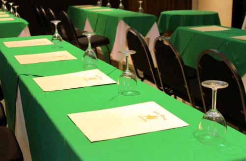 a row of green tables with wine glasses on them at Hotel Estrella in Managua