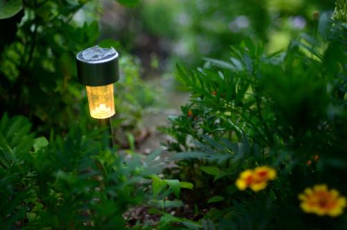 a small light in a garden with flowers at Guest House Konjic in Konjic
