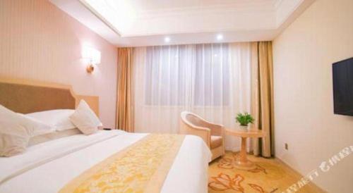 a hotel room with a bed and a television at Vienna 3 Best Shanghai Baoshan Fengxiang Road in Shanghai