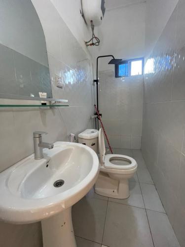 a white bathroom with a sink and a toilet at Zanzibar beach escape 1&2 in Bwejuu
