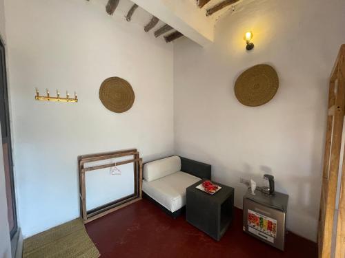 a small room with a mirror and a chair at Zanzibar beach escape 1&2 in Bwejuu