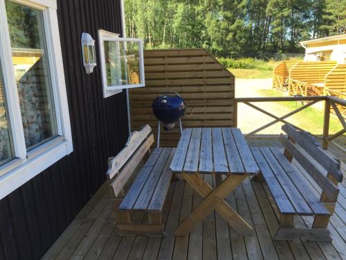a wooden bench sitting on the porch of a house at Motel E4 Kolmården Apartments And Cottages in Kolmården