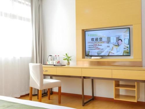 a room with a desk with a television on it at GreenTree Inn Jiaxin Puyuan Kaixuan Road in Jiaxing