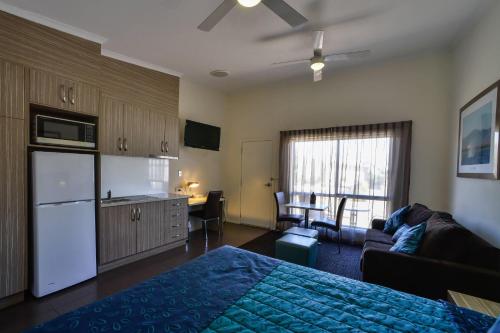 a bedroom with a bed and a kitchen with a couch at Comfort Inn & Suites Augusta Westside in Port Augusta