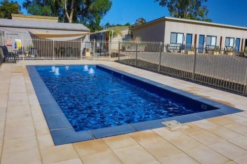 a swimming pool with blue water in a yard at Comfort Inn & Suites Augusta Westside in Port Augusta