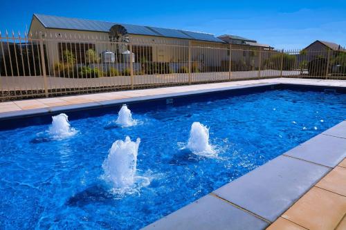 a swimming pool with three statues in the water at Comfort Inn & Suites Augusta Westside in Port Augusta