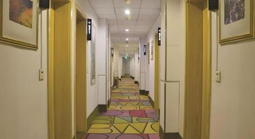 a long hallway with colorful floors in a building at Shell Baoding Dongfeng Middle Road Kailian Hotel in Baoding