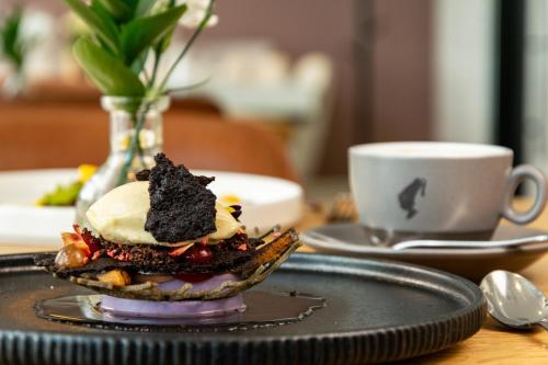 a dessert on a plate on a table with a cup of coffee at Strandhotel Ostende in Ahlbeck