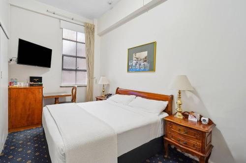 a bedroom with a bed and a desk and a television at Castlereagh Boutique Hotel, an Ascend Collection Hotel in Sydney