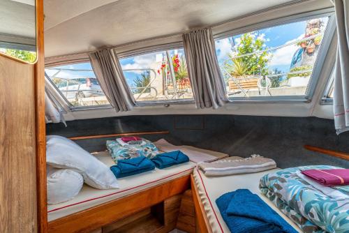 two beds in the back of a boat with windows at Penichette Odyssey Croisieres in Bellegarde