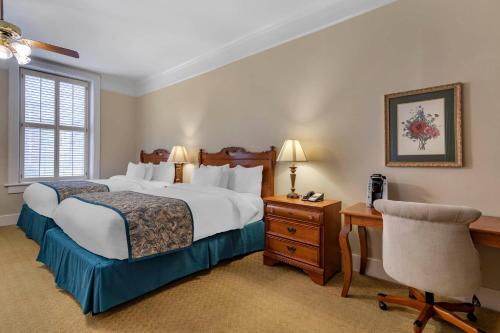 a bedroom with a bed and a desk and a chair at Windsor Hotel, an Ascend Collection Hotel in Americus